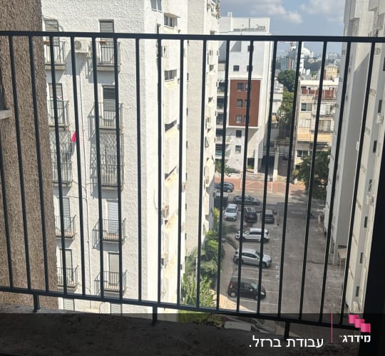 מעקה מתכת במרפסת עם נוף לבניינים